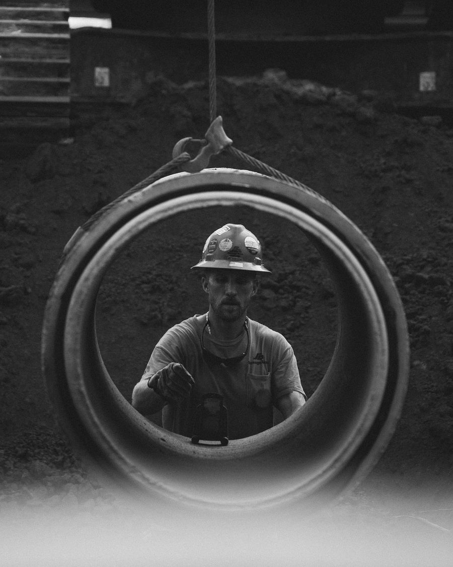 A pipe crew member framed through a section of concrete pipe
