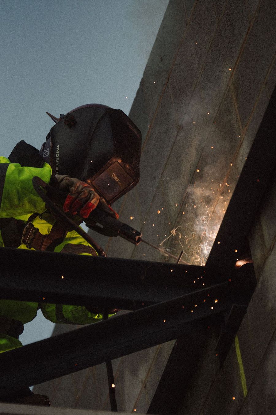 A welder throws sparks on structural steel