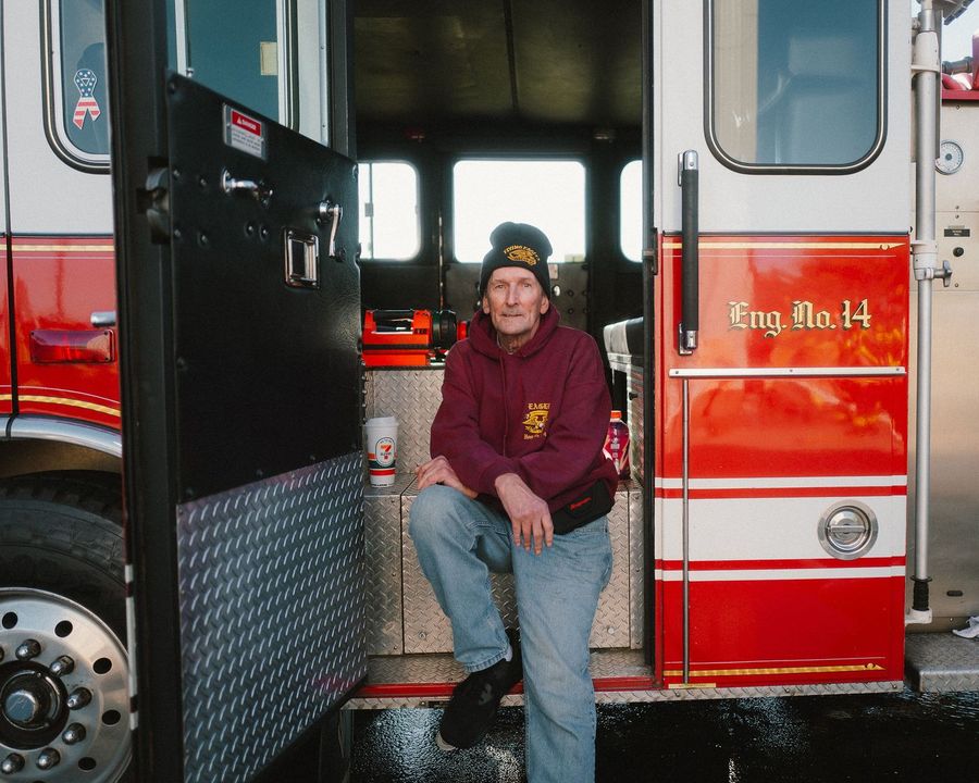 A firefighter sits in the cab doorway of Engine 14