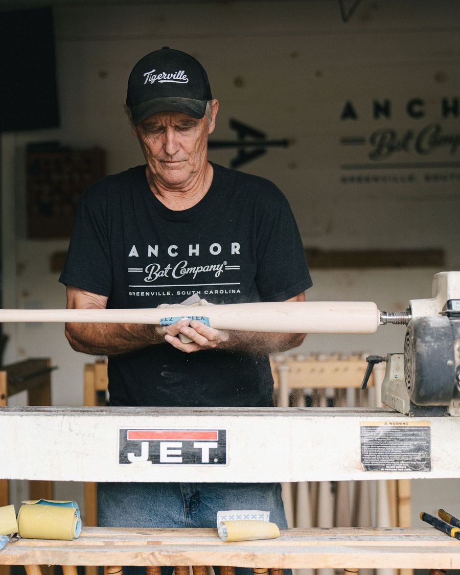 A craftsman sands a bat on the lathe at Anchor Bat Company