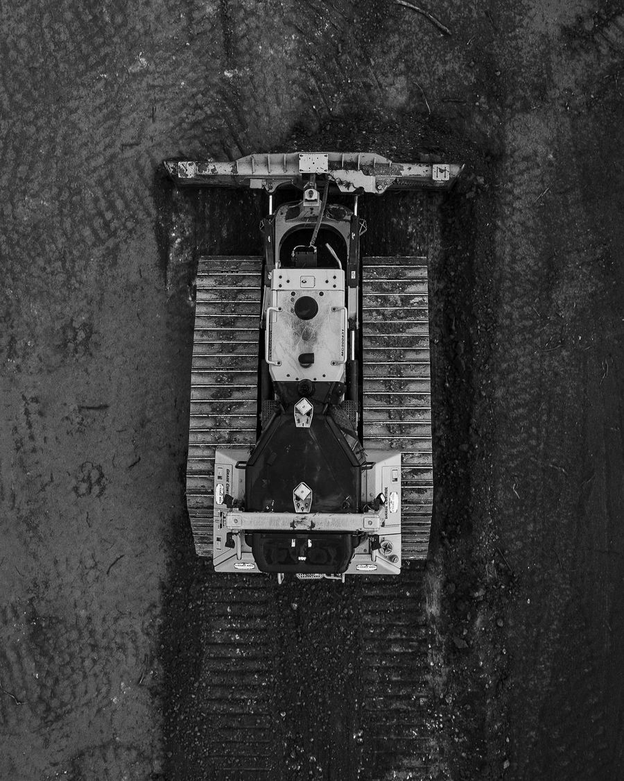 Overhead view of a dozer on a dark graded pad