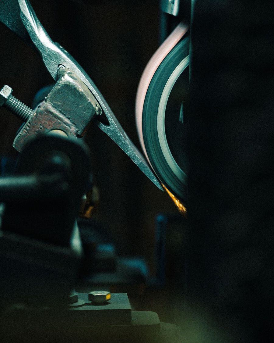 A grinder throws sparks in a metal shop