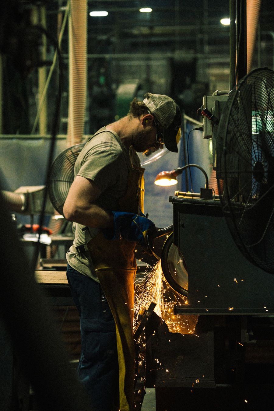 A grinder throws sparks in a metal shop